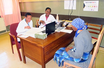 Dr. Yehoda Martei with a breast cancer patient in a clinic in Botswana
